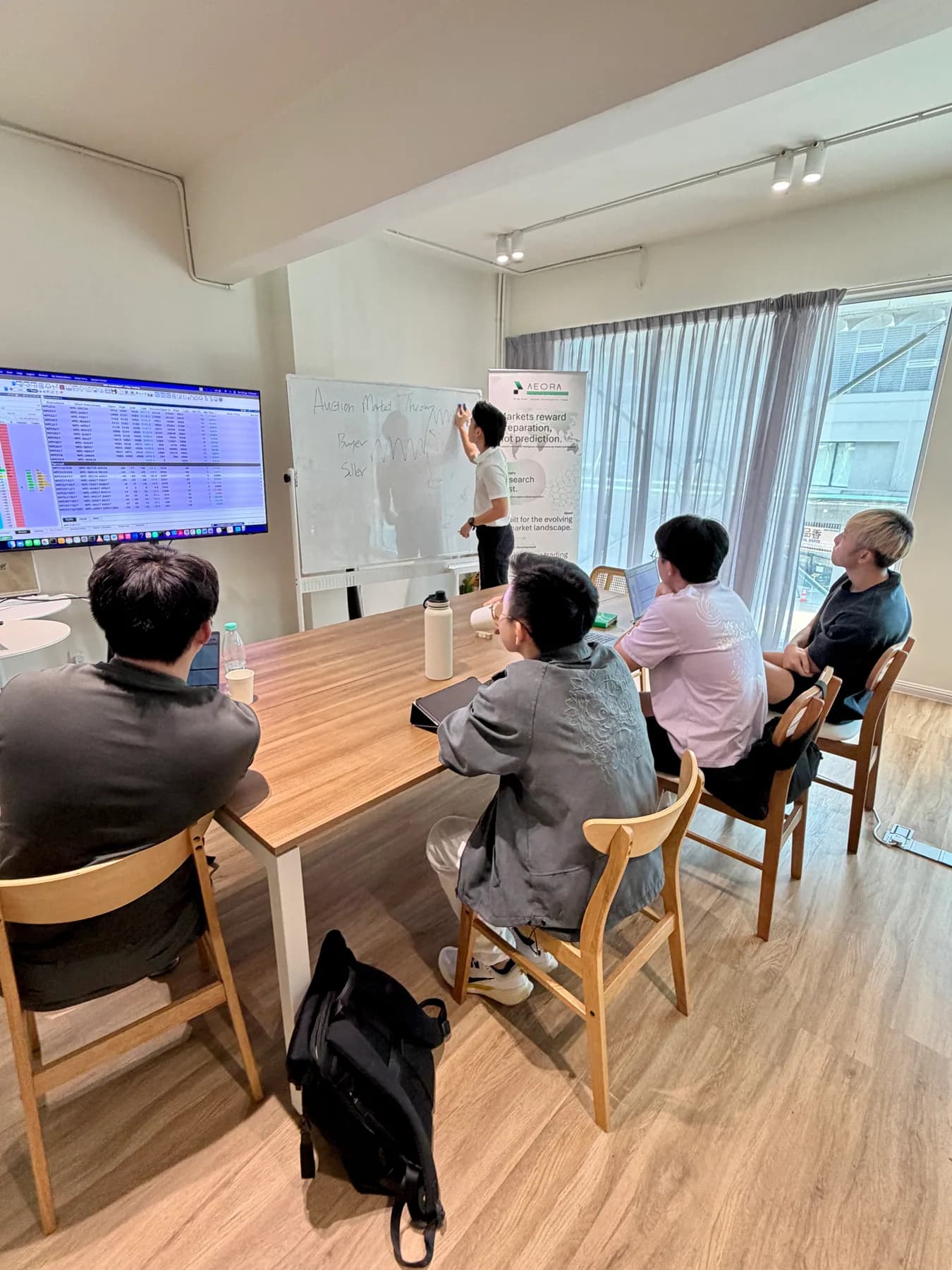 Aeora facilitator explaining auction market theory in the classroom